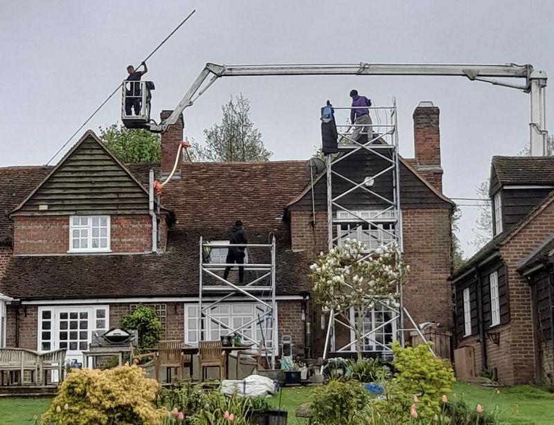 The Roof Moss Cleaners using cherry picker and scaffolding to clean roof safely and professionally in Thrapston, Northamptonshire